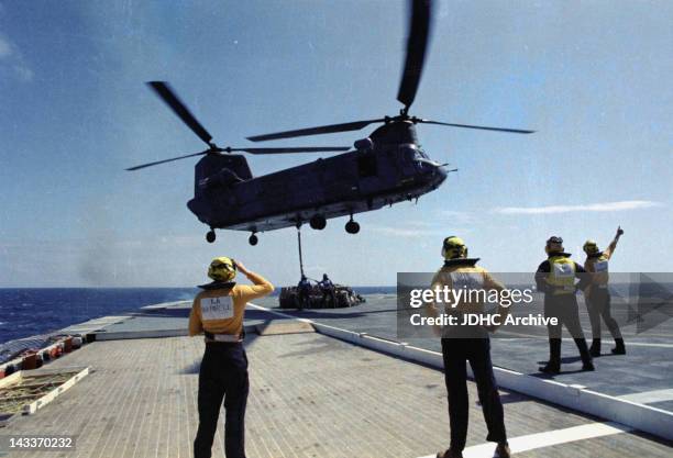 Chinook helicopter lifts supplies from a helipad on board the Cunard liner 'RMS Queen Elizabeth 2', which has been requisitioned as a British...