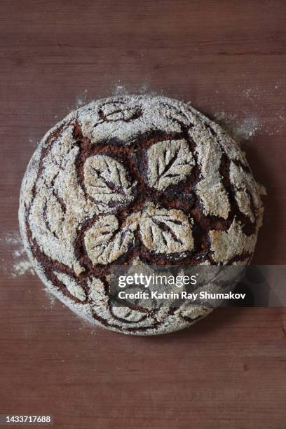 dutch oven rustic rye bread with floral pattern scored atop - rye bread stock pictures, royalty-free photos & images