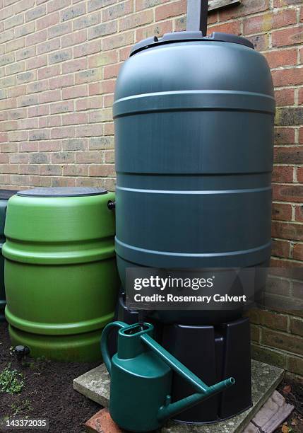 watering can  filled from linked water butts - rainwater tank stock pictures, royalty-free photos & images