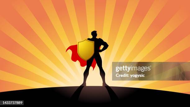 vector superhero silhouette in power pose holding shield with sunburst effect stock illustration - superhero shield stock illustrations