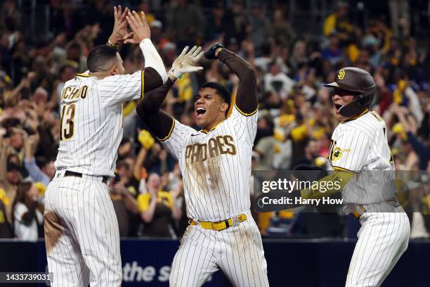 Juan Soto and Ha-Seong Kim celebrate with Manny Machado of the San Diego Padres after scoring two runs during the seventh inning to go up 5-3 against...