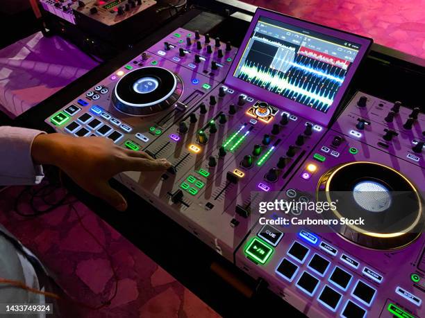 dj playing music at mixer closeup - listening party fotografías e imágenes de stock