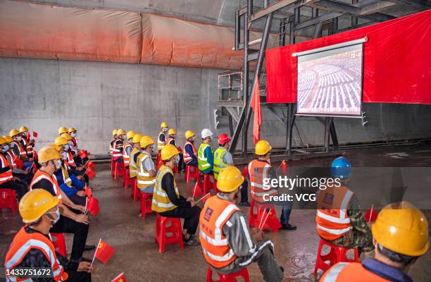 Construction workers watch a live broadcast of the opening session of the 20th National Congress of the Communist Party of China on October 16, 2022...
