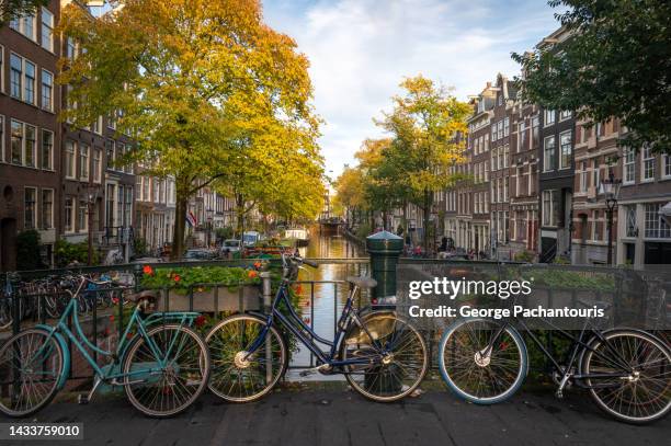 bicycles on a bridge in amsterdam, holland - keizersgracht stockfoto's en -beelden