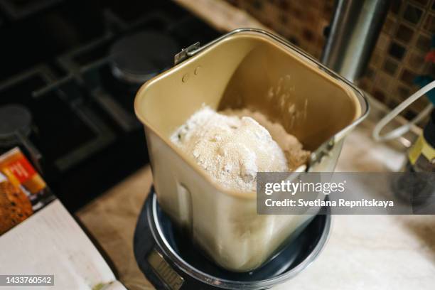 cooking in the kitchen in a bread machine in a cozy home - pure yeast stock-fotos und bilder