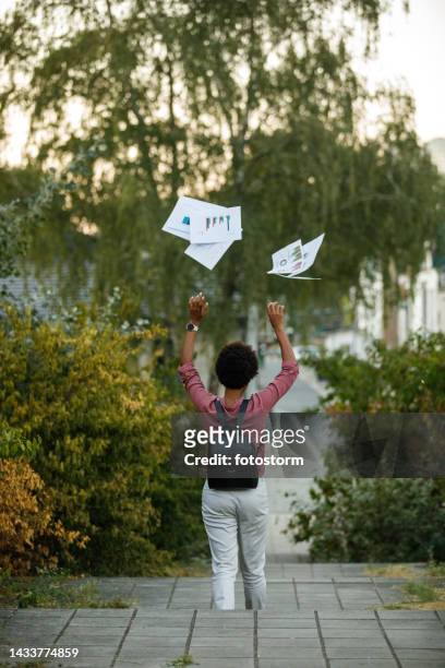 rear view of a mature woman throwing documents - throwing paper stock pictures, royalty-free photos & images