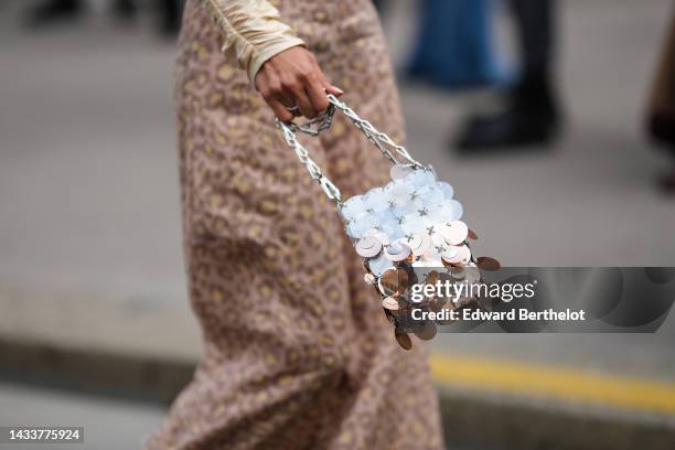 Xiayan wears a beige with pale yellow leopard print pattern high waist long skirt, a silver 1969 Nano metal-disc shoulder bag from Paco Rabanne,...