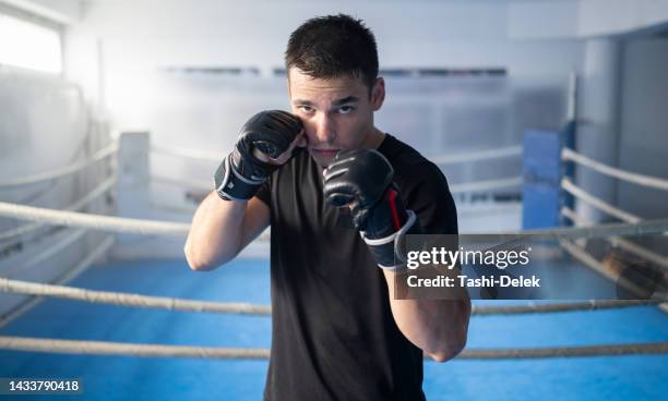 portrait of young male mma fighter exercising in the gym - boxing young men stock pictures, royalty-free photos & images