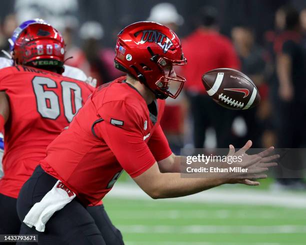 Quarterback Harrison Bailey of the UNLV Rebels bobbles a snap before completing a pass against the Air Force Falcons during their game at Allegiant...