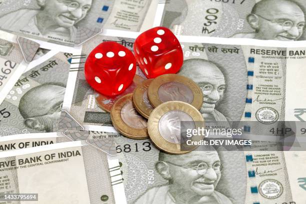 dice and rupee coins on indian currency notes - gandhi stock-fotos und bilder