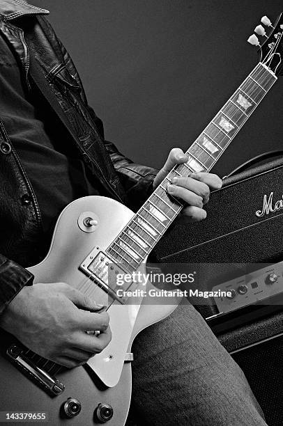 This image has been converted to black and white) A close-up of a man playing a Gibson Custom Historic Series 57 Les Paul Standard electric guitar,...