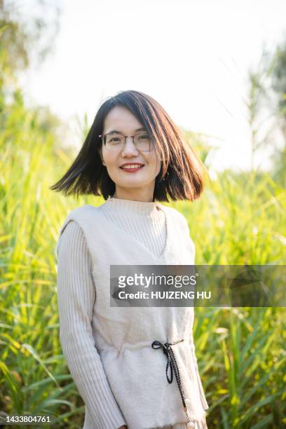 beautiful asian woman in field. hair blowing in the wind - asian woman short hair stock pictures, royalty-free photos & images