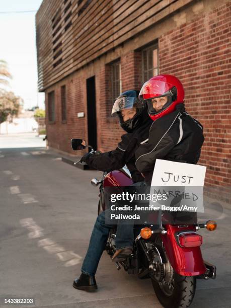 caucasian couple riding on motorcycle with just married sign - casco moto blanco fotografías e imágenes de stock