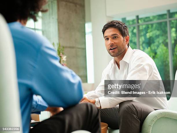 businessmen talking together in lobby - face to face interview stock pictures, royalty-free photos & images
