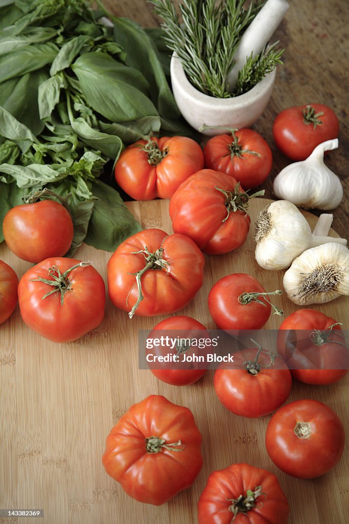 Tomatoes, garlic and basil on cutting board