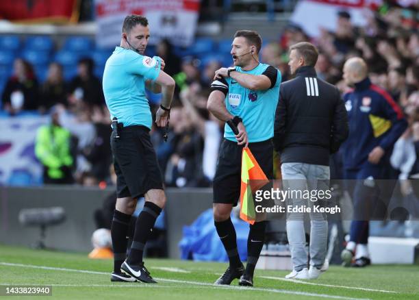 Referee Chris Kavanagh speaks to their fourth official regarding communications issues prior to the Premier League match between Leeds United and...