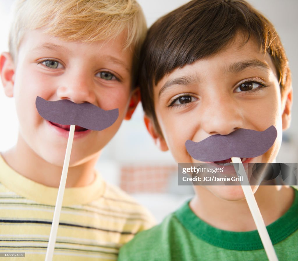 Boys playing with costume mustaches