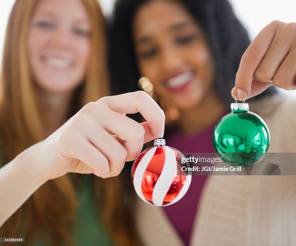 Friends holding small Christmas ornaments