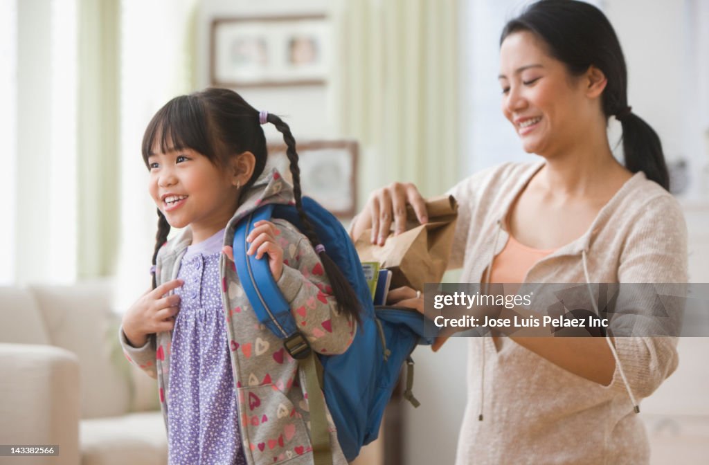 Asian mother helping daughter get ready for school