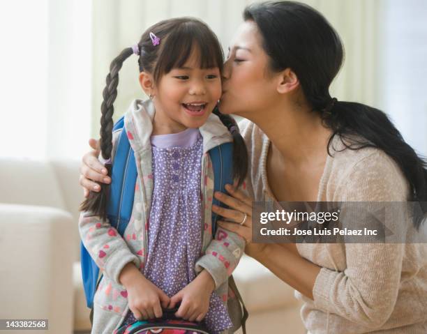 asian mother kissing daughter - first day school hug stock pictures, royalty-free photos & images