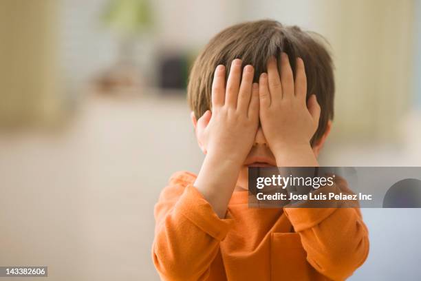 mixed race boy covering his eyes - mani sugli occhi foto e immagini stock