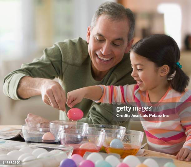 grandfather and granddaughter decorating easter eggs - dye stock-fotos und bilder