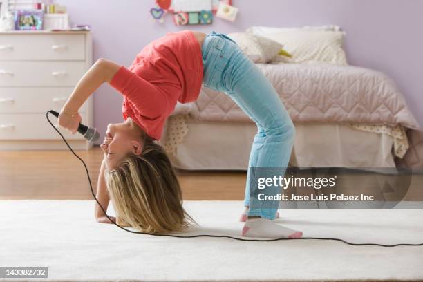 caucasian girl doing back bend and singing into microphone - head back stock pictures, royalty-free photos & images