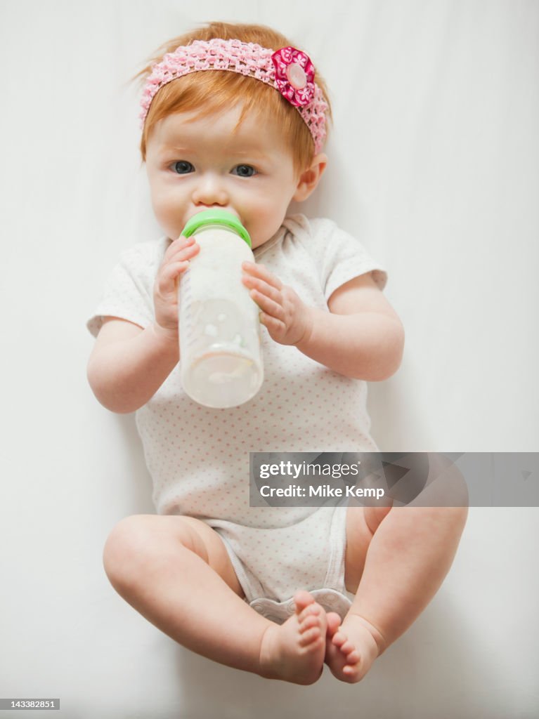 Caucasian baby girl drinking bottle