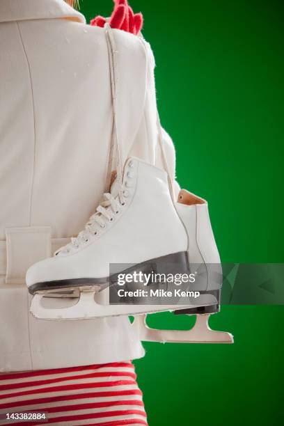 mixed race woman carrying ice skates - indoor skating stock pictures, royalty-free photos & images