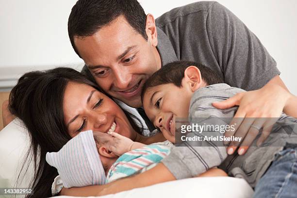 hispanic family looking at newborn baby - baby father hug side stock-fotos und bilder