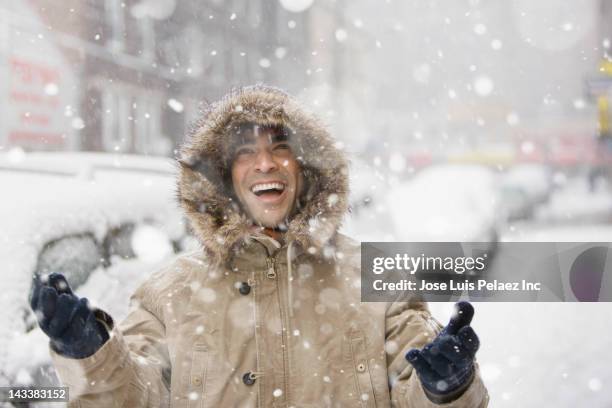 man enjoying snow in city - snow scene stock pictures, royalty-free photos & images