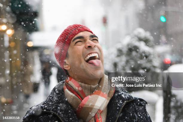 man enjoying snow in city - man tongue stock pictures, royalty-free photos & images