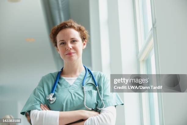 caucasian surgeon standing in hospital - redhead doctor stock pictures, royalty-free photos & images