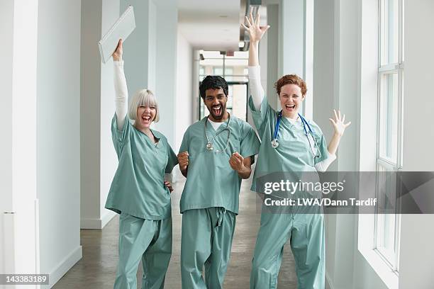 excited surgeons standing together in hospital - a celebration of arts education stockfoto's en -beelden