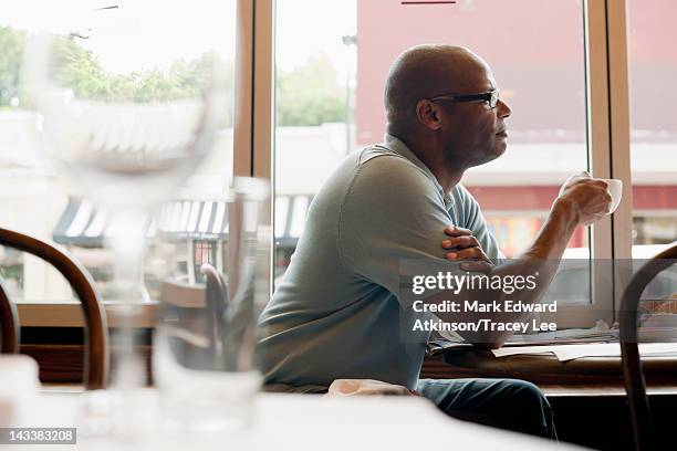 african american man drinking coffee in restaurant - customer profile stock pictures, royalty-free photos & images