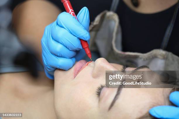 kosmetikerin beim auftragen von permanent make-up - permanent make up stock-fotos und bilder