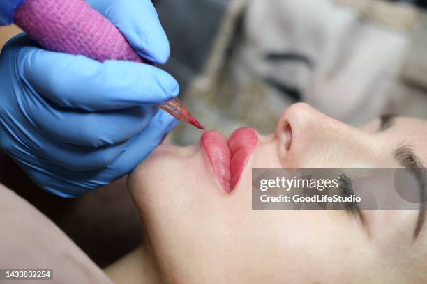 kosmetikerin beim auftragen von permanent make-up - permanent make up stock-fotos und bilder