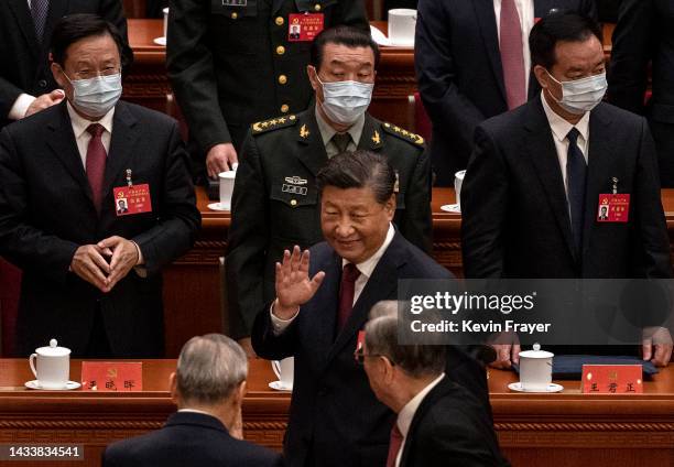 Chinese President Xi Jinping, centre, waves to senior members of the government as he leaves at the end of the Opening Ceremony of the 20th National...