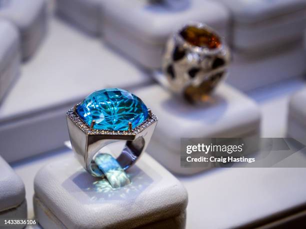 macro close up sapphire & topaz coloured gemstone set rings arranged in a row in jewellery store shop setting. luxury ring display with shining colourful stones and diamonds. high end luxury shopping. - topaz stock pictures, royalty-free photos & images