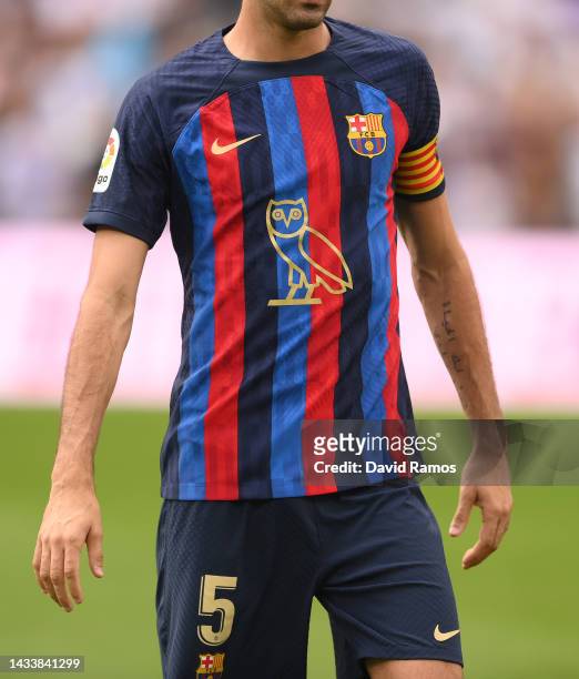 Sergio Busquets of FC Barcelona looks on wearing the modified OVO owl logo on the front of the FC Barcelona shirt, which celebrates Canadian musician...
