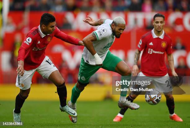 Joelinton of Newcastle United holds off Casemiro of Manchester United during the Premier League match between Manchester United and Newcastle United...