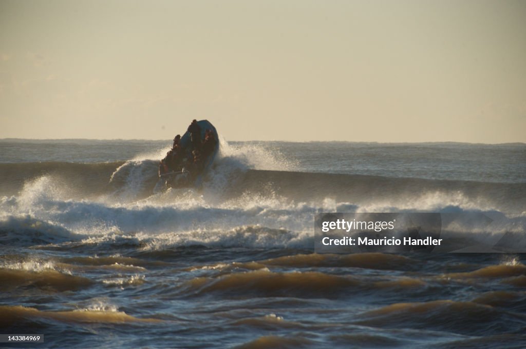 A fishing boat plows through the surf.