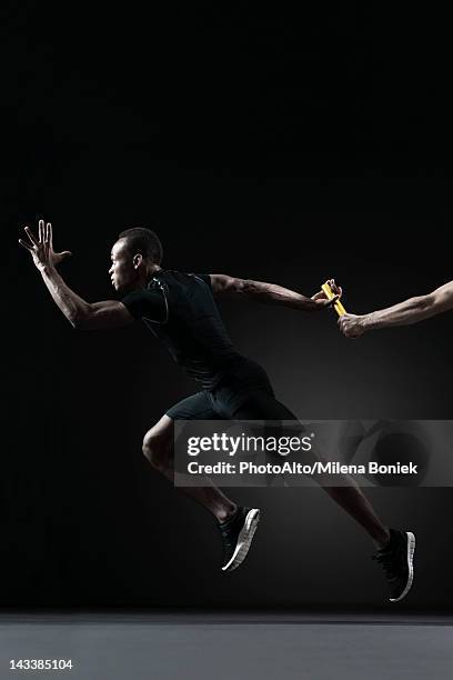 runners passing baton - athletics relay stock pictures, royalty-free photos & images