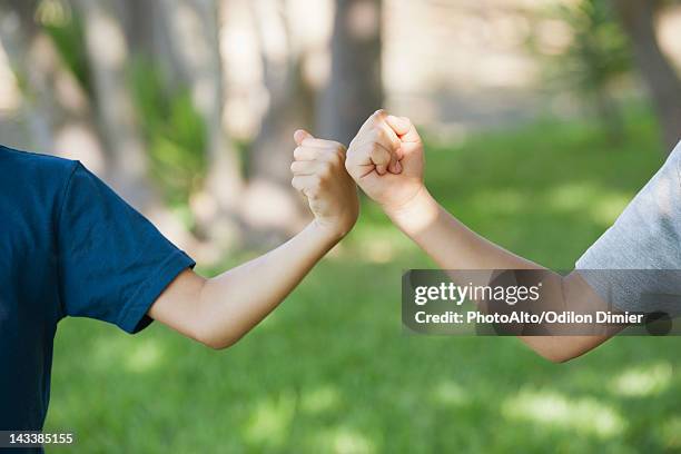 young friends doing fist bump, cropped - solo bambini maschi foto e immagini stock