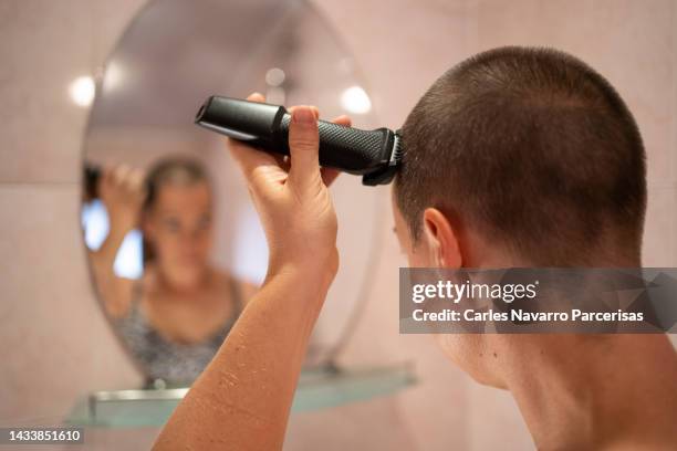 woman with cancer shaving her hair - shaving head stock pictures, royalty-free photos & images