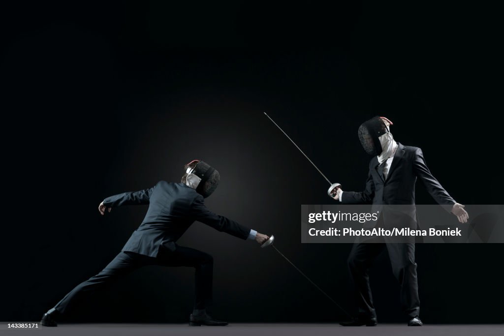 Businessmen fencing