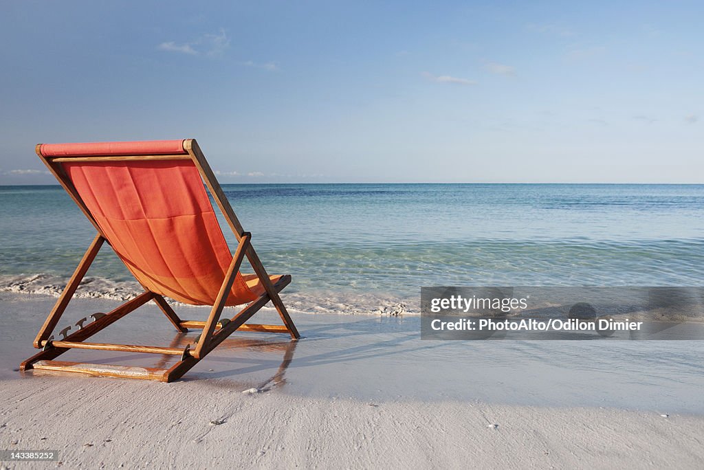 Empty deckchair on beach