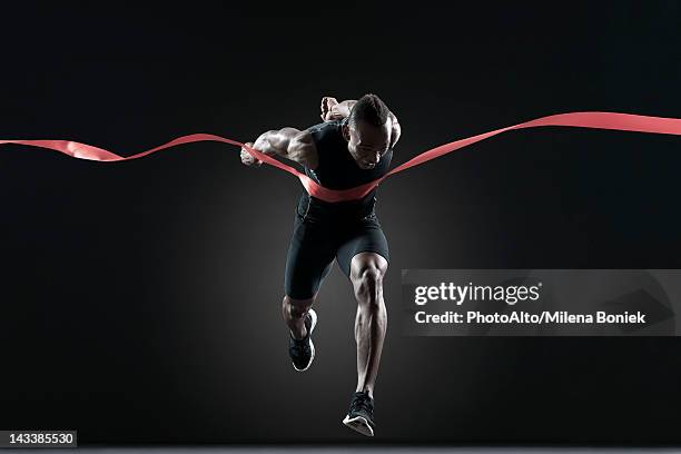 runner crossing finish line - traguardo foto e immagini stock