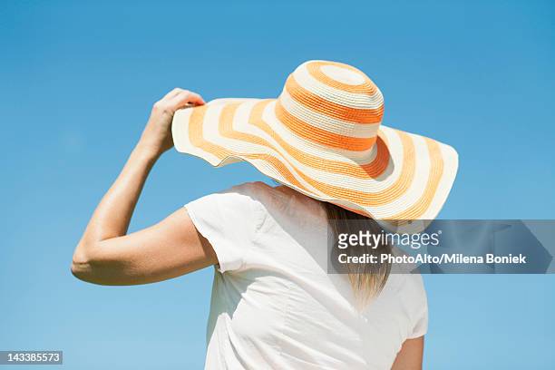 woman wearing sun hat, rear view - zonnehoed stockfoto's en -beelden