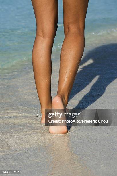 woman walking in surf at the beach, low section - 人の脚 ストックフォトと画像